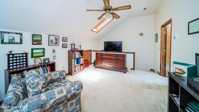 carpeted living area featuring a ceiling fan, visible vents, and lofted ceiling with skylight