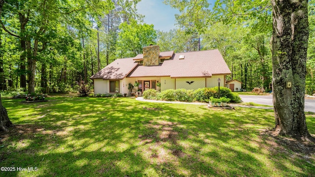 view of front of property featuring a chimney and a front yard