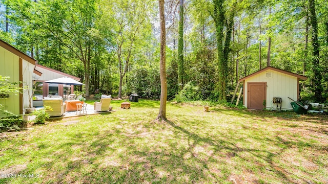 view of yard featuring a storage shed, an outbuilding, an outdoor living space, and a patio area