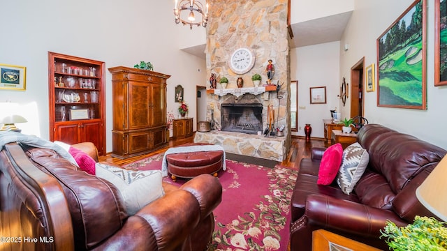 living area featuring a high ceiling, a fireplace, and wood finished floors