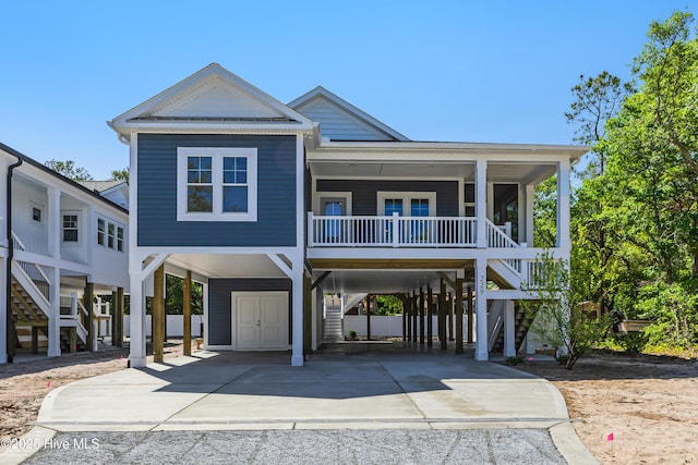 coastal home featuring stairs, a carport, and concrete driveway
