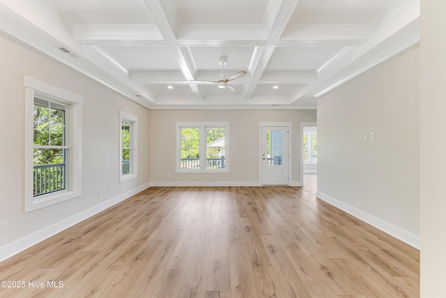 empty room featuring baseboards, light wood finished floors, visible vents, and beamed ceiling