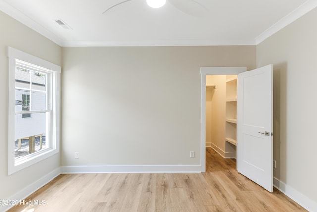 unfurnished room with crown molding, visible vents, baseboards, a ceiling fan, and light wood finished floors