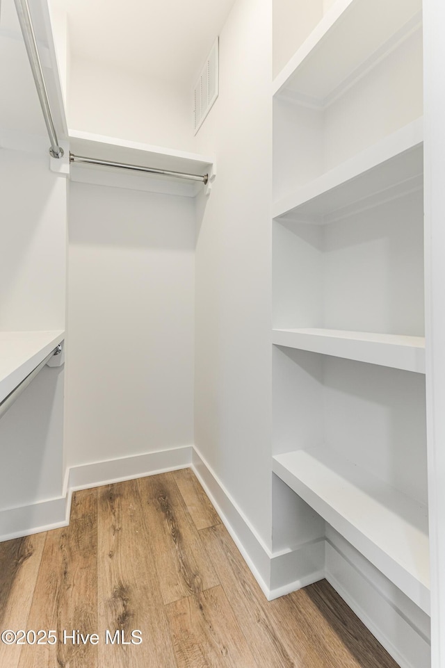walk in closet featuring visible vents and wood finished floors