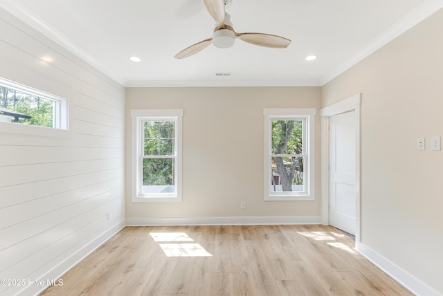 spare room with ornamental molding, light wood finished floors, and a wealth of natural light