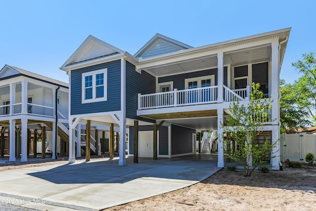 view of front of property featuring a porch, concrete driveway, stairway, and a carport