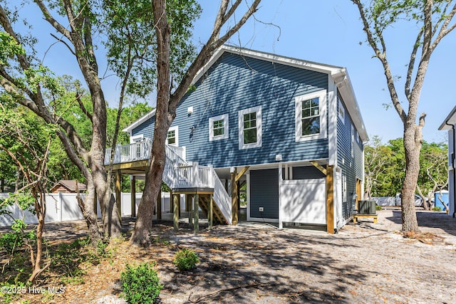 back of house with fence, a wooden deck, and stairs