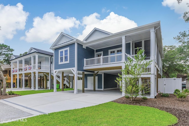 229 NE 34th St, Oak Island, NC 28465 - coastal inspired home featuring a carport, concrete driveway, a porch, and stairway