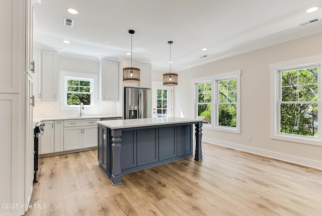kitchen featuring visible vents, white cabinetry, appliances with stainless steel finishes, and a kitchen island