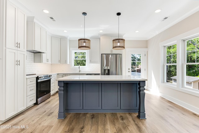 kitchen featuring light countertops, appliances with stainless steel finishes, and a wealth of natural light