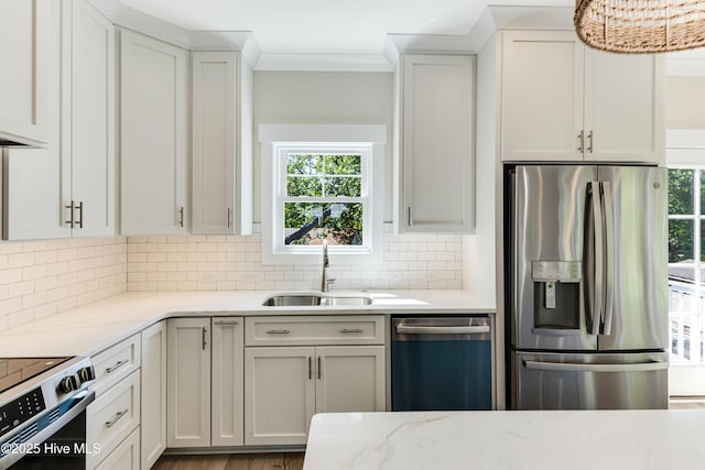 kitchen featuring dishwashing machine, stainless steel refrigerator with ice dispenser, a sink, and a wealth of natural light
