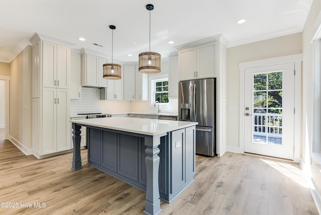 229 NE 34th St, Oak Island, NC 28465 - kitchen featuring stainless steel fridge with ice dispenser, electric range oven, crown molding, a kitchen island, and light wood-style floors