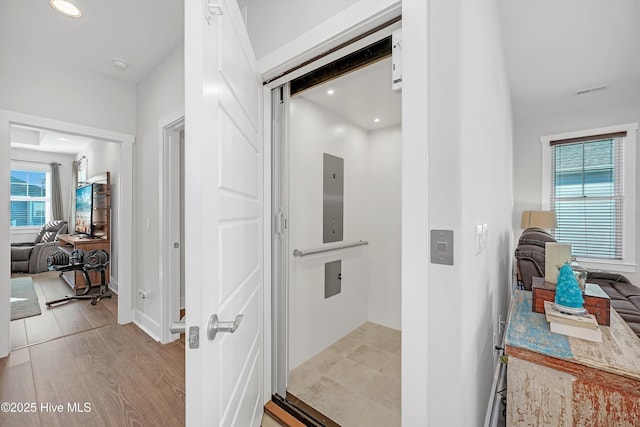 305 Ivy Ln, Carolina Beach, NC 28428 - hallway with healthy amount of natural light, elevator, recessed lighting, baseboards, and light wood-style floors