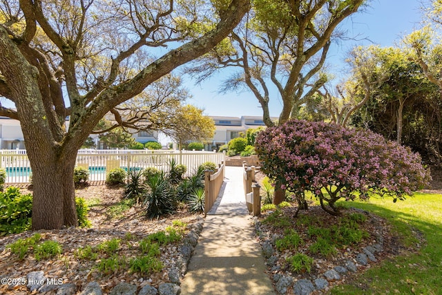 view of property's community with fence and a swimming pool