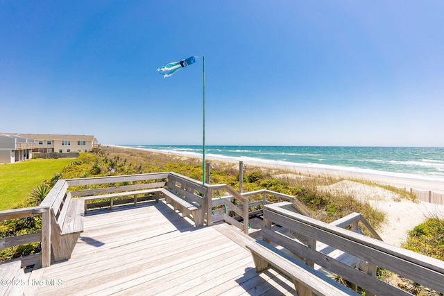 wooden deck with a beach view and a water view