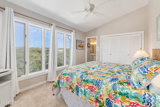 bedroom featuring a ceiling fan, vaulted ceiling, baseboards, a closet, and light carpet