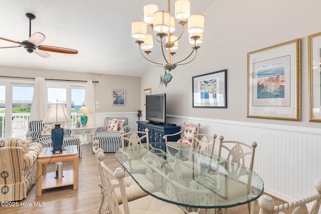 dining room featuring wainscoting, ceiling fan with notable chandelier, and wood finished floors
