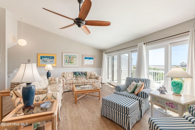 living room featuring light wood-style floors, a ceiling fan, and lofted ceiling