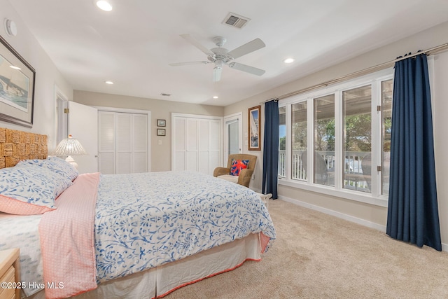 bedroom with multiple closets, recessed lighting, carpet floors, and visible vents