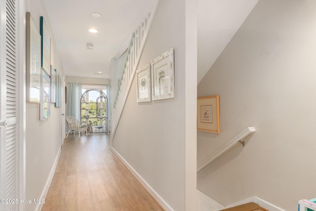 hallway with recessed lighting, baseboards, stairway, and light wood-type flooring