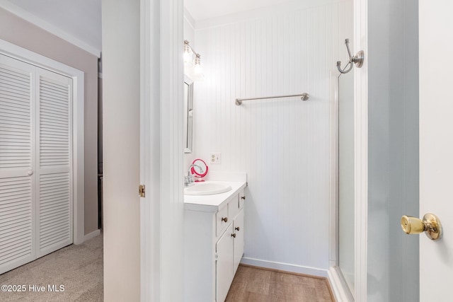 full bath featuring vanity, baseboards, and a shower with shower door