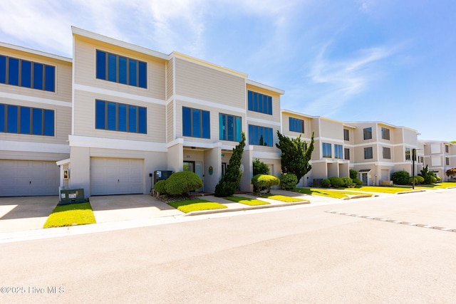 view of front of property with a garage, stucco siding, driveway, and a residential view