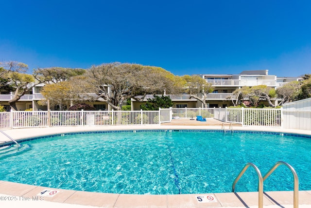 community pool featuring fence and a residential view