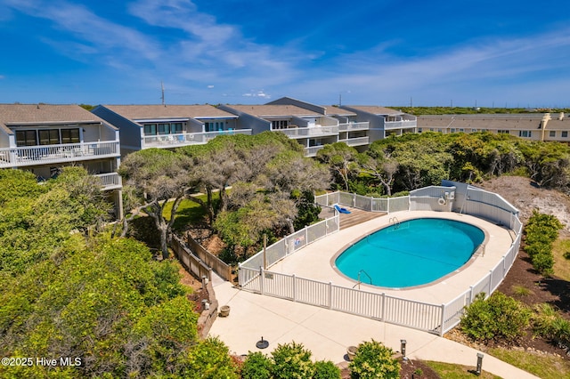 pool with fence and a residential view