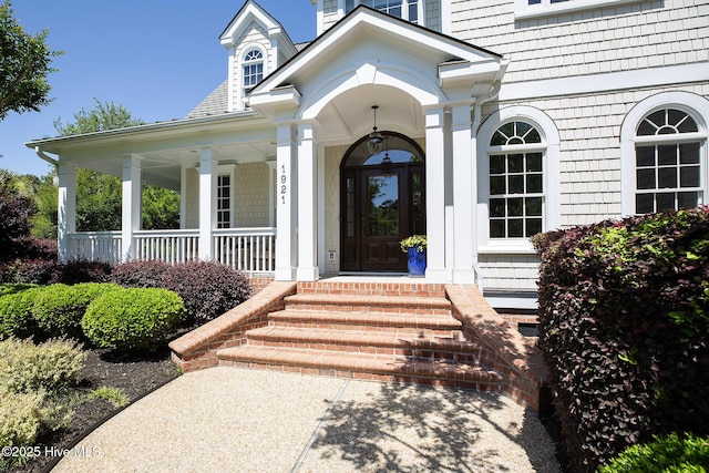 doorway to property with covered porch and a chimney
