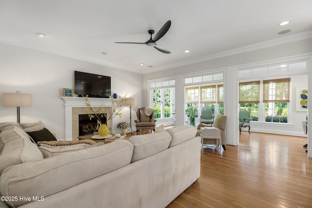 living room with ornamental molding, wood finished floors, recessed lighting, a tile fireplace, and a ceiling fan