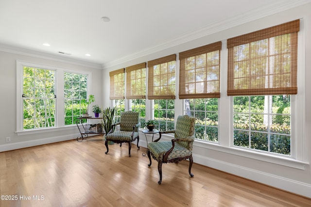 sunroom / solarium with baseboards, crown molding, and wood finished floors