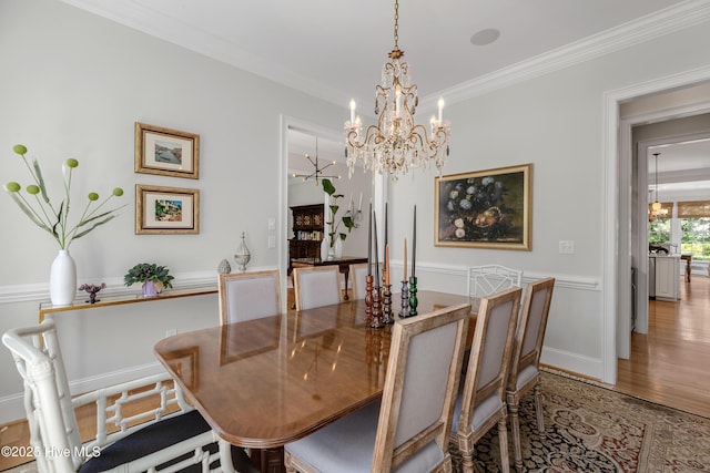 dining room featuring an inviting chandelier, crown molding, and wood finished floors