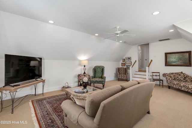 living area with visible vents, baseboards, vaulted ceiling, and light carpet