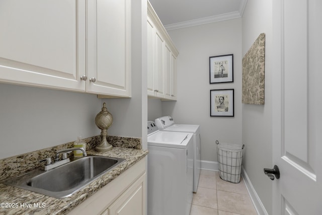 washroom with washing machine and clothes dryer, light tile patterned flooring, crown molding, cabinet space, and a sink