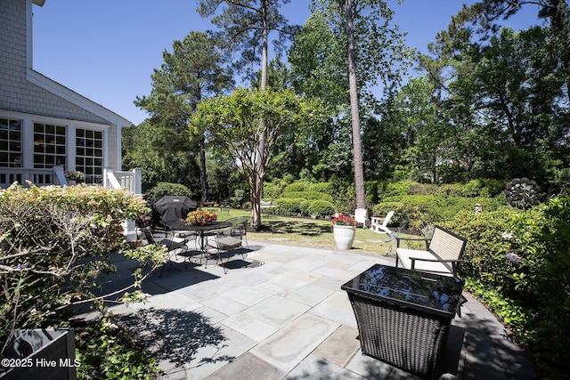 view of patio with grilling area, outdoor dining area, and an outdoor fire pit