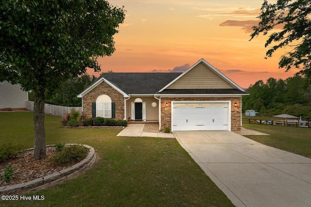 view of front of house featuring a lawn, driveway, and stone siding
