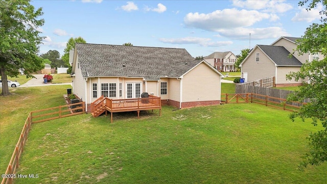 back of house featuring a lawn, a wooden deck, a fenced backyard, and roof with shingles