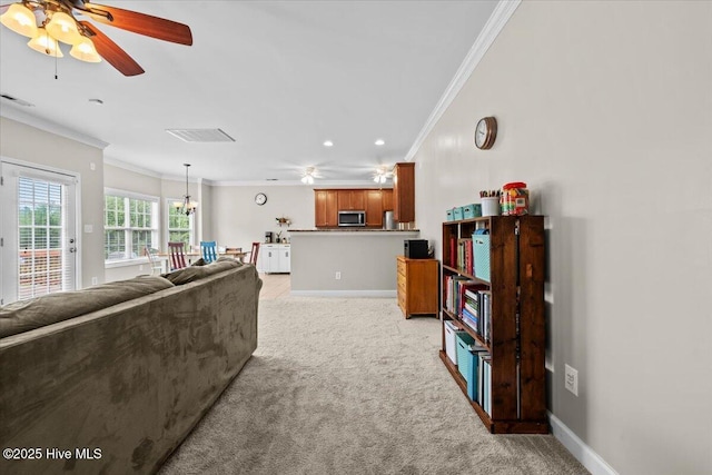 living area with crown molding, ceiling fan, and light colored carpet