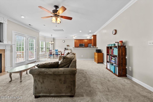 living area featuring a ceiling fan, baseboards, ornamental molding, and light carpet