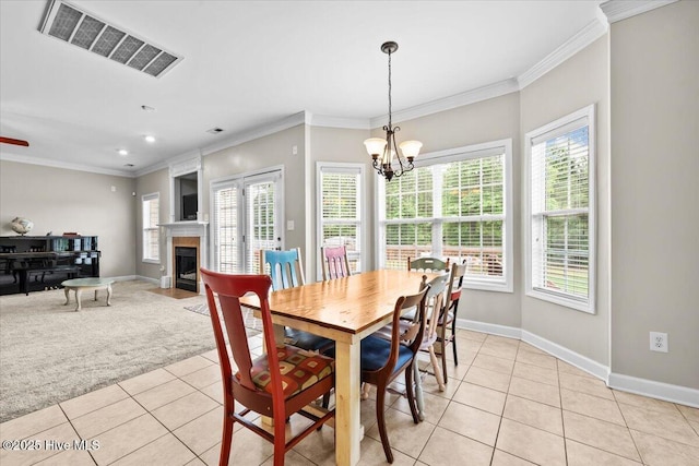 dining space featuring visible vents, crown molding, baseboards, a notable chandelier, and light tile patterned flooring