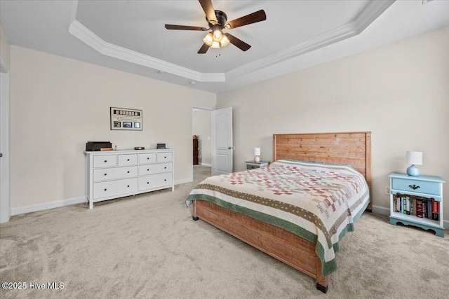 bedroom featuring ornamental molding, carpet, a tray ceiling, and ceiling fan