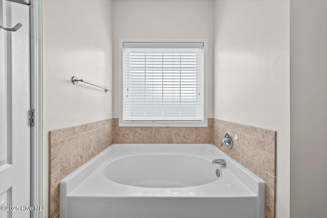 full bathroom featuring a healthy amount of sunlight and a bath