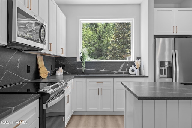 kitchen featuring appliances with stainless steel finishes, white cabinets, and dark countertops
