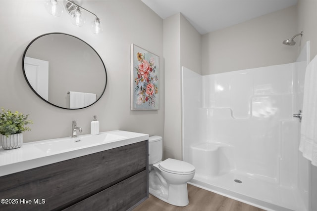 full bathroom with vanity, walk in shower, toilet, and wood finished floors