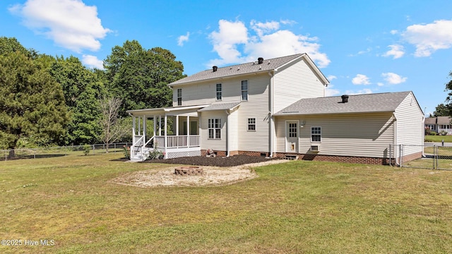 rear view of house featuring roof with shingles, a sunroom, crawl space, a fenced backyard, and a lawn