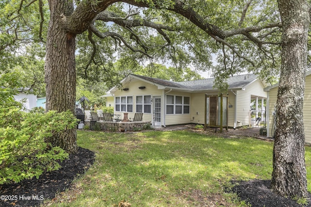 121 NW 1st St, Oak Island, NC 28465 - rear view of property featuring a sunroom and a yard