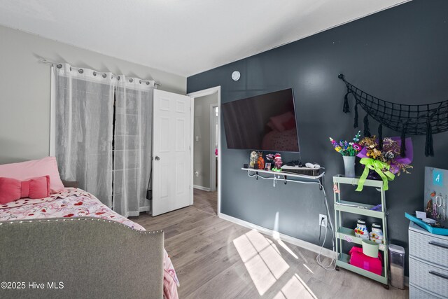bedroom with baseboards and wood finished floors