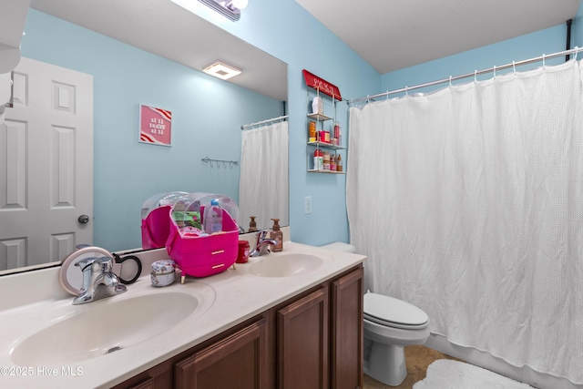 bathroom featuring double vanity, toilet, tile patterned floors, and a sink