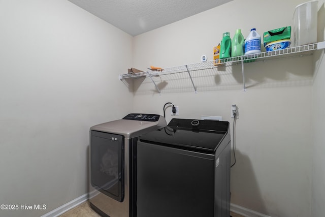 washroom featuring baseboards, laundry area, and washer and dryer