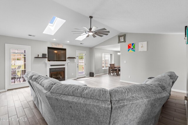 living area featuring baseboards, visible vents, and wood finished floors